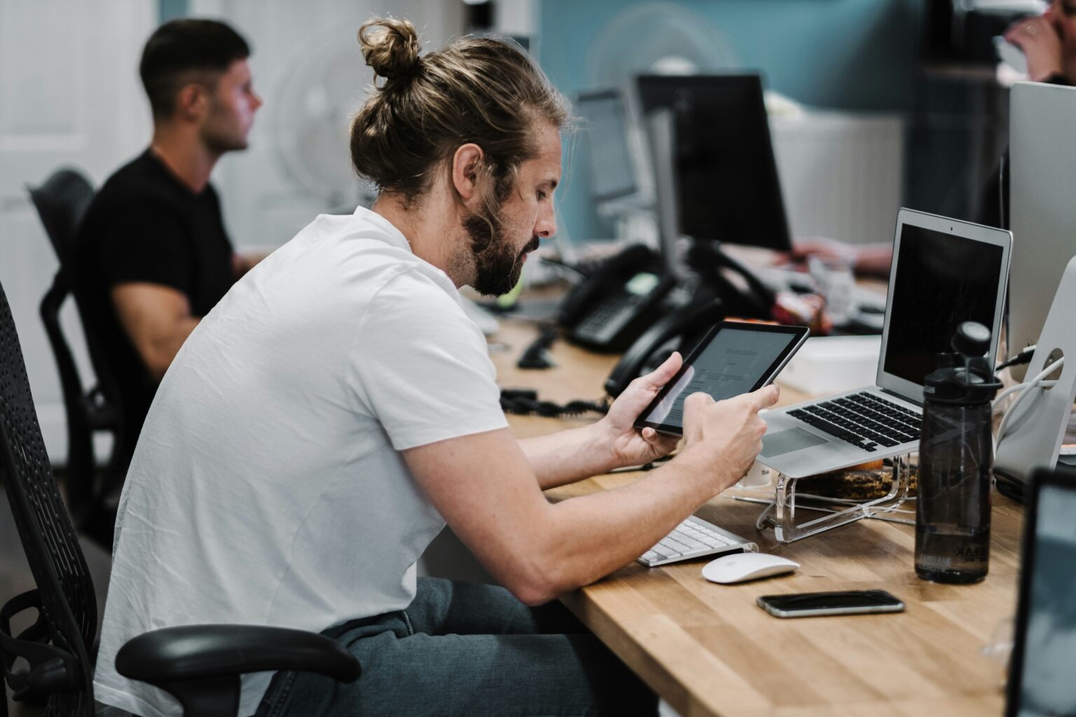 studio-republic-qeij_dhDhGg-unsplash A man at a desk in the office, using a tablet